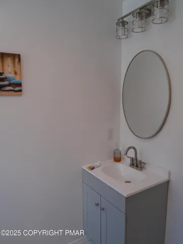 an empty room with wooden floor and fan