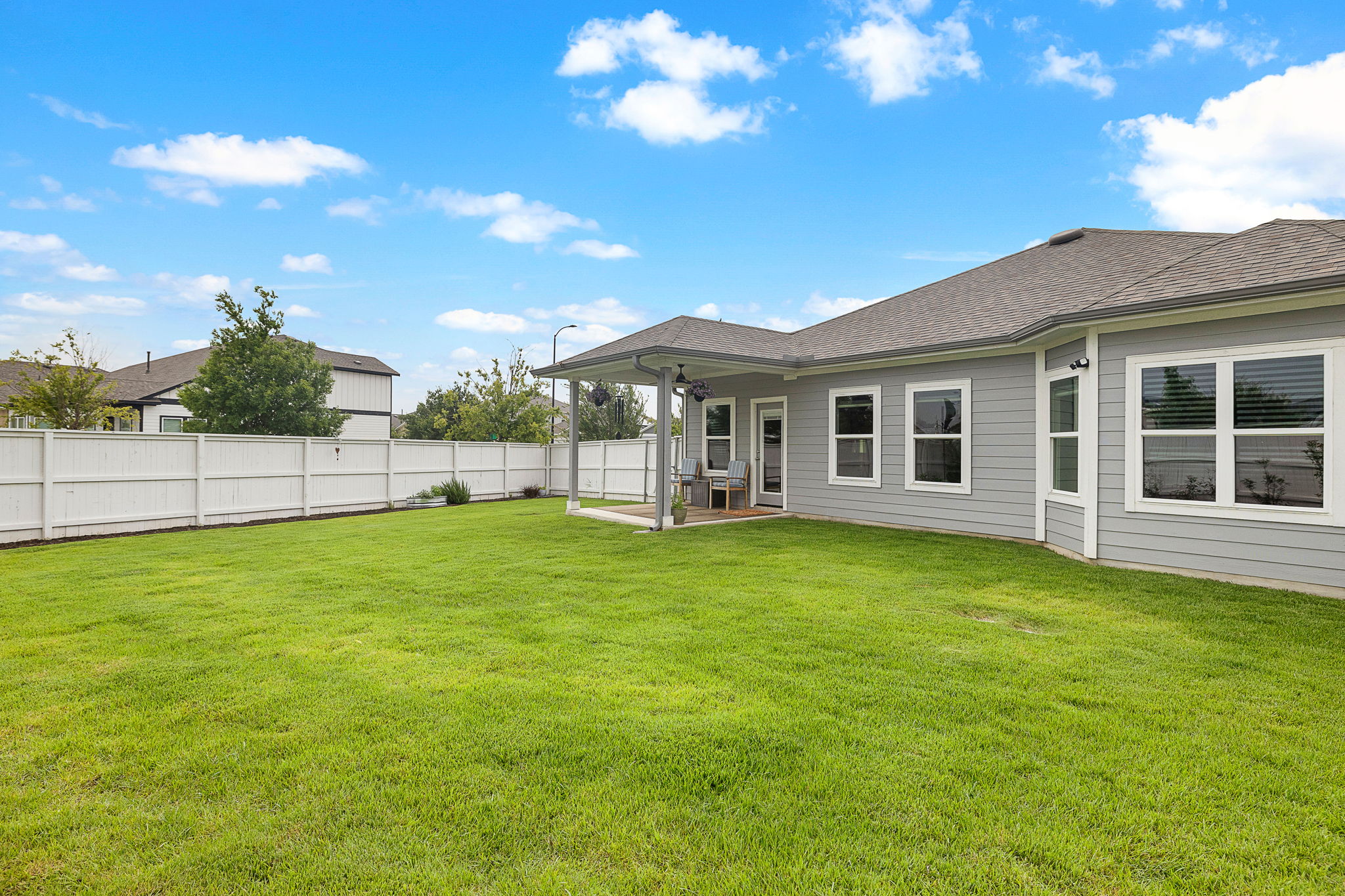 234 Appleberry Lane Elgin, TX 78621 - Photo 24 of 28 A wide view of the backyard shows just how much care has gone into the lawn, landscaping, and outdoor space.