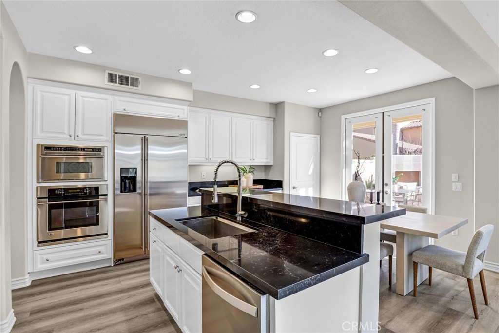 8 Ingleside Irvine, CA 92620 - Photo 12 of 74 a kitchen with granite countertop stainless steel appliances a sink stove and refrigerator