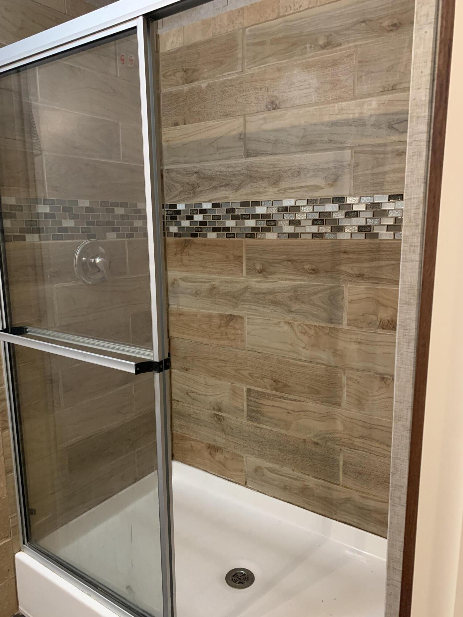 6214 Barnes Road Crestview, FL 32536 - Photo 11 of 23 a bathroom with a glass shower door