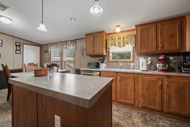 a kitchen with stainless steel appliances granite countertop a sink window and cabinets