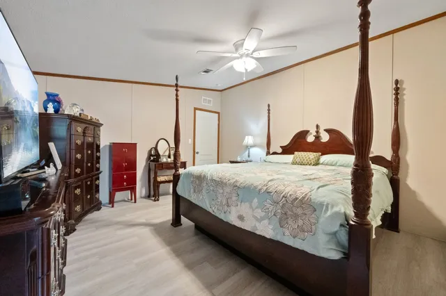 a bedroom with a large bed and a chandelier