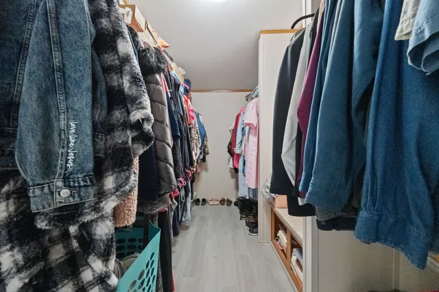a view of walk in closet with clothes