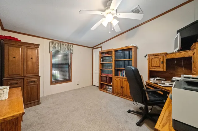 a view of a workspace with furniture and a window