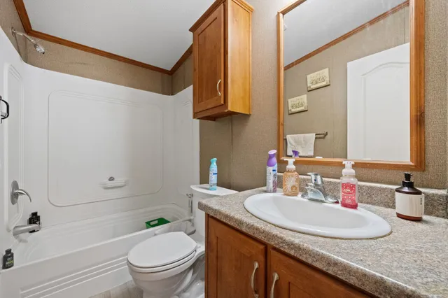 a bathroom with a granite countertop sink toilet and a mirror