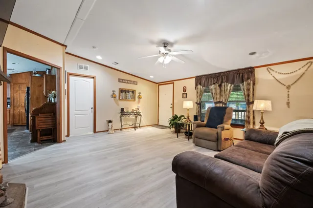 a living room with furniture and a ceiling fan