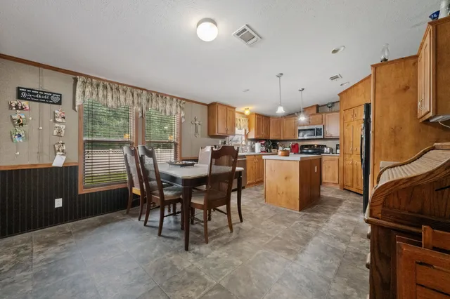 a kitchen with a table chairs refrigerator and cabinets