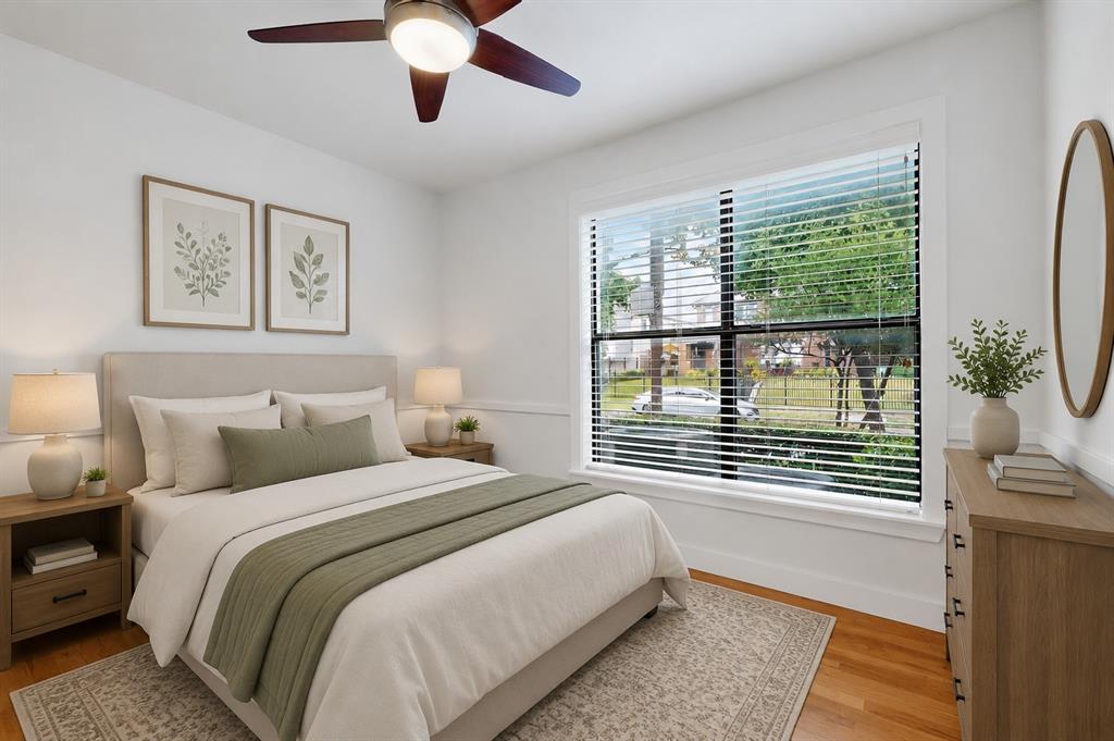 4211 Rawlins Street, Unit 528 Dallas, TX 75219 - Photo 12 of 14 Bright bedroom featuring wood-finish flooring, a large window with horizontal blinds, and a ceiling fan with integrated lighting