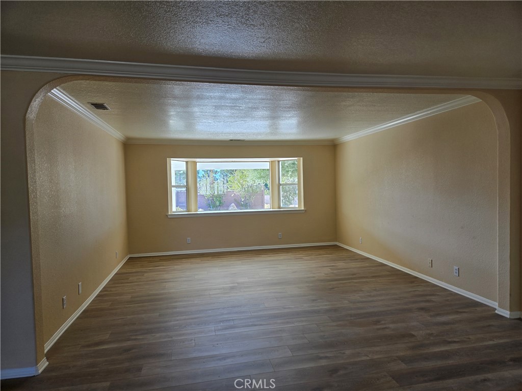19345 Oneida Road Apple Valley, CA 92307 - Photo 16 of 19 an empty room with wooden floor and windows