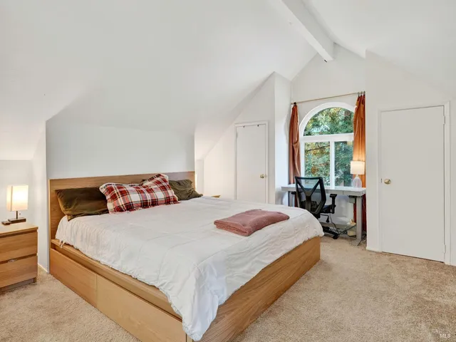 a bedroom with a bed and a large window