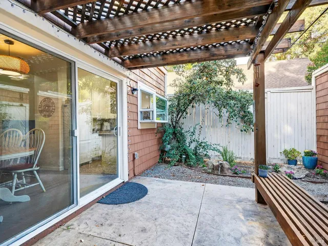 a view of a porch with chairs and potted plants