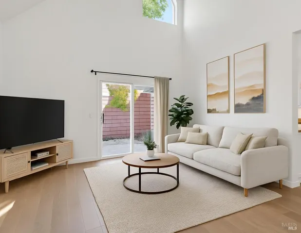 a living room with furniture a flat screen tv and a large window