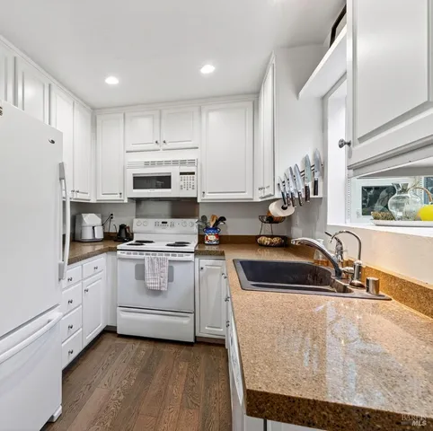 a kitchen with stainless steel appliances granite countertop a sink a stove and a refrigerator