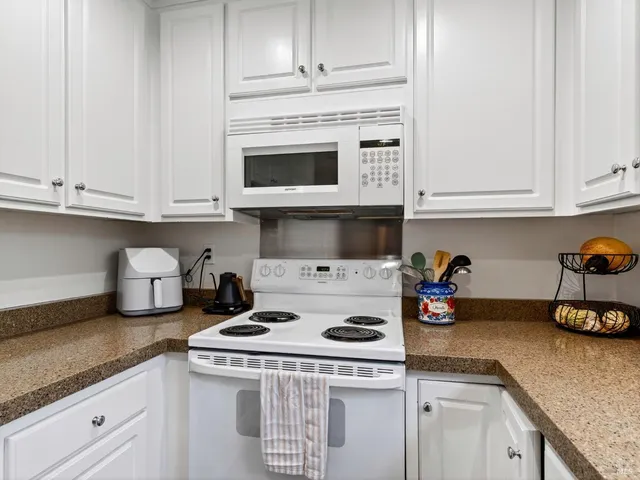 a kitchen with appliances a stove and cabinets