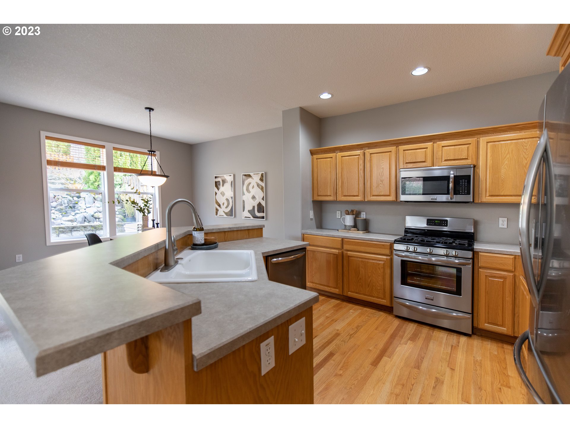 2399 Southwest Border Way Gresham, OR 97080 - Photo 11 of 48 a kitchen with stainless steel appliances granite countertop a stove top oven a sink a counter space and cabinets