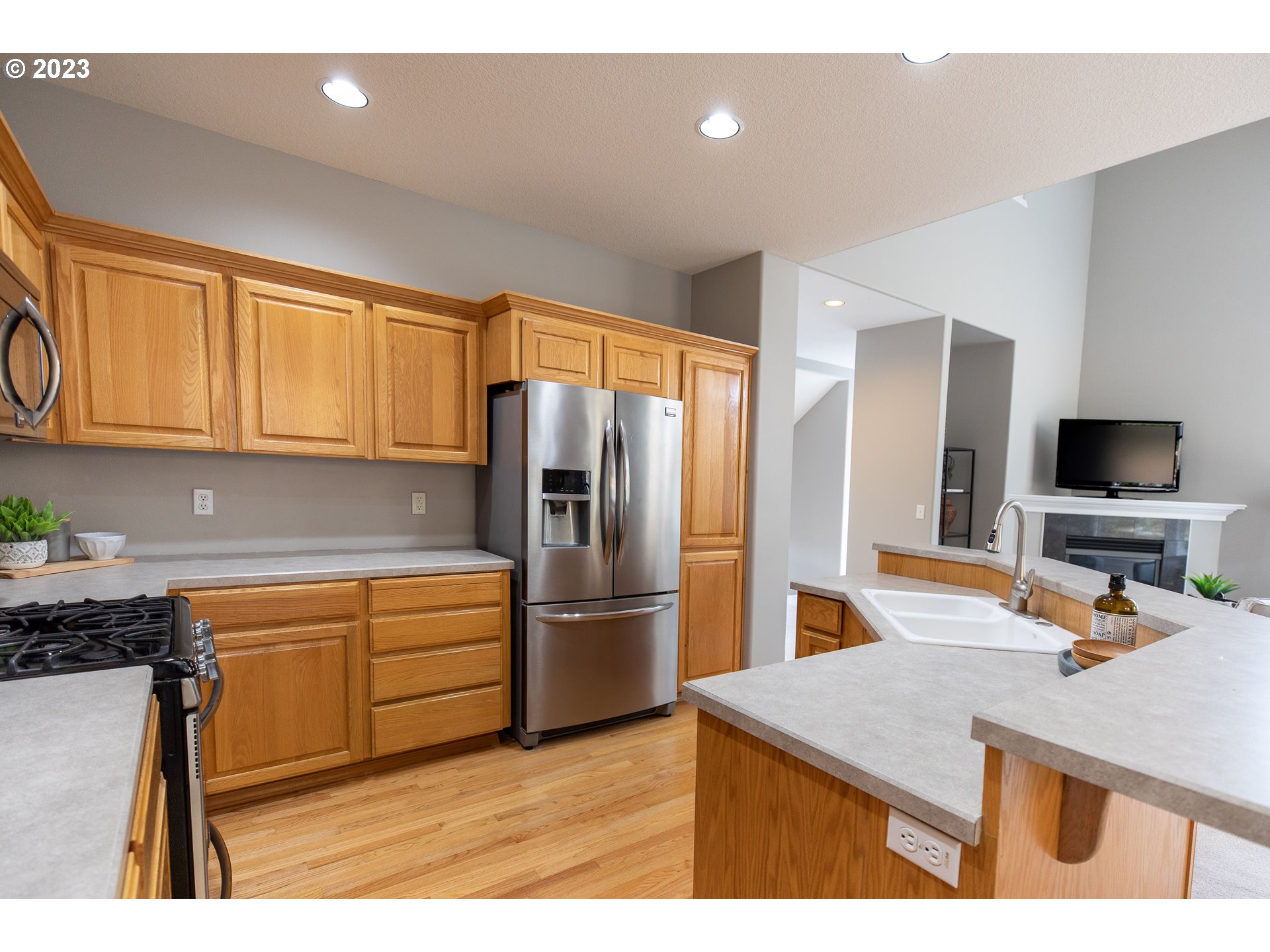 2399 Southwest Border Way Gresham, OR 97080 - Photo 13 of 48 a kitchen with kitchen island a counter top space appliances and a sink