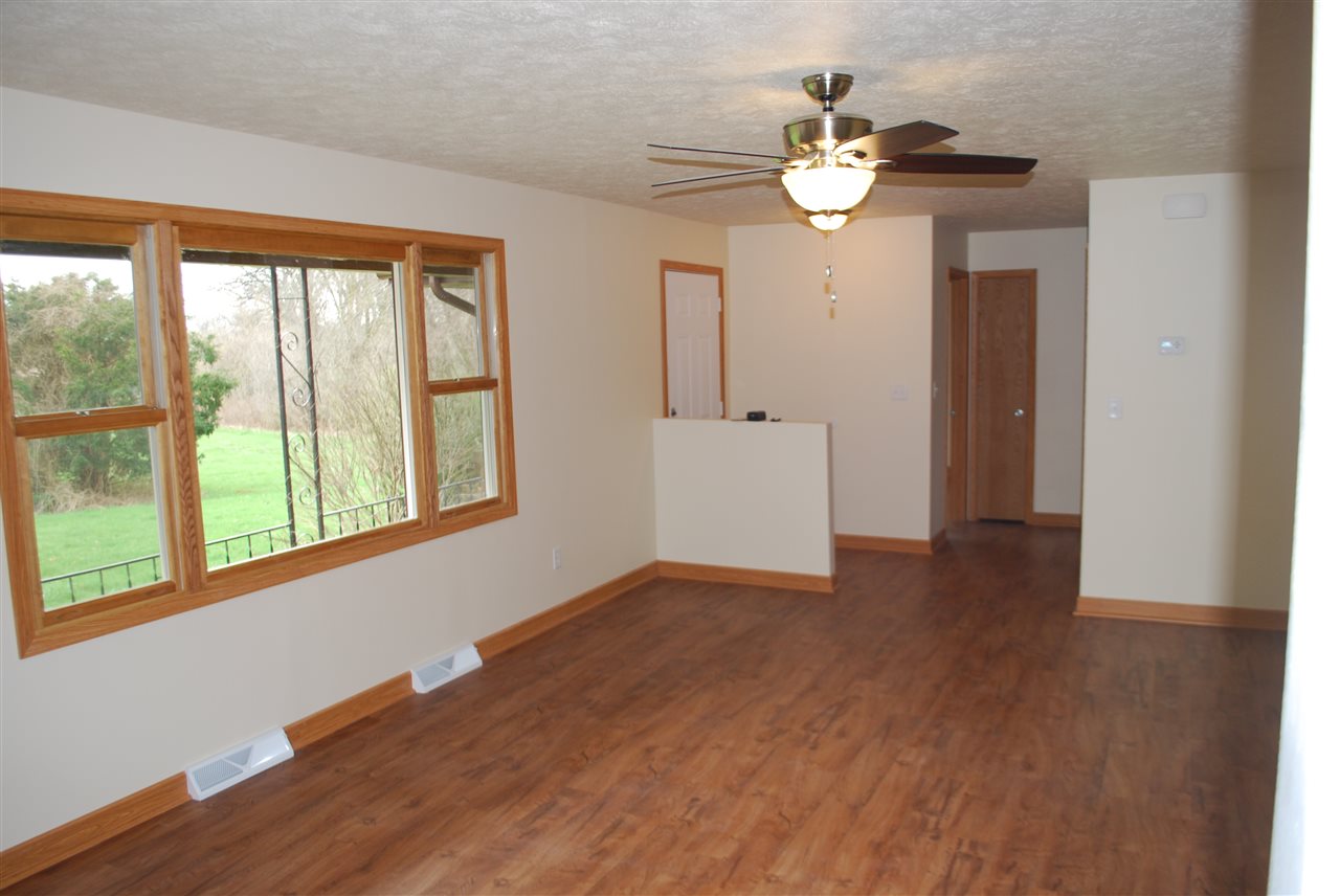 7941 Fairdale Road Cherry Valley, IL 61016 - Photo 2 of 18 a view of an empty room with wooden floor and a window