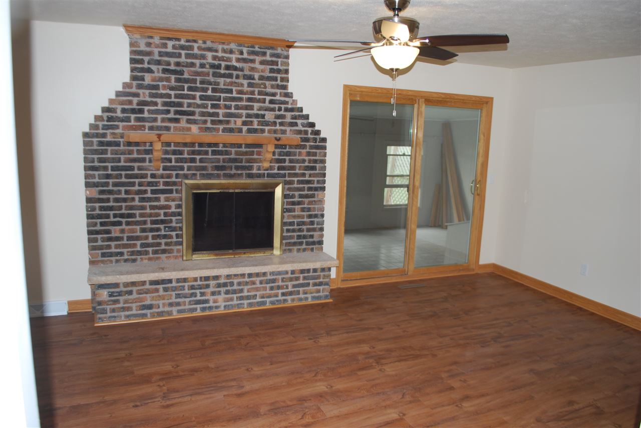 7941 Fairdale Road Cherry Valley, IL 61016 - Photo 5 of 18 a view of an empty room with a fireplace and wooden floor