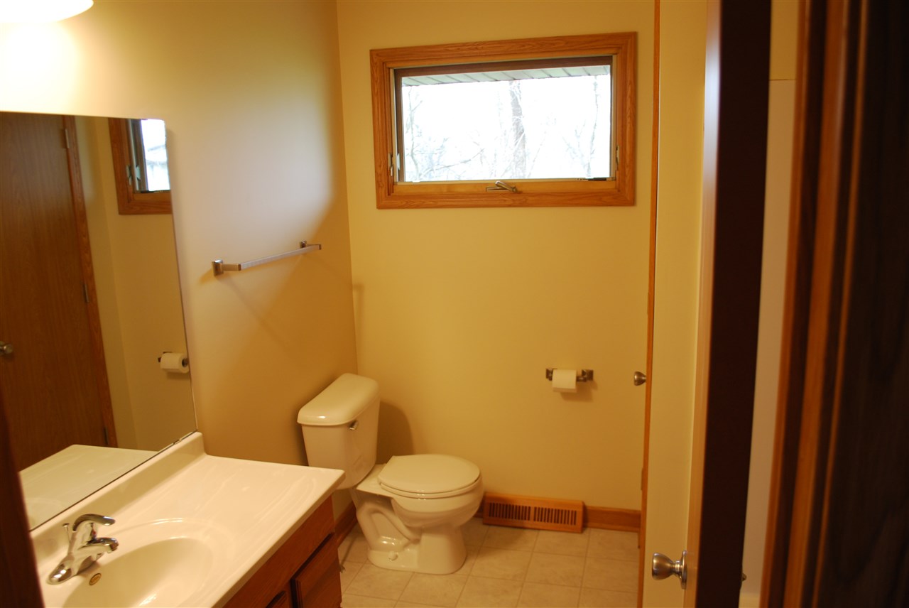 7941 Fairdale Road Cherry Valley, IL 61016 - Photo 8 of 18 a bathroom with a granite countertop toilet a sink and a mirror