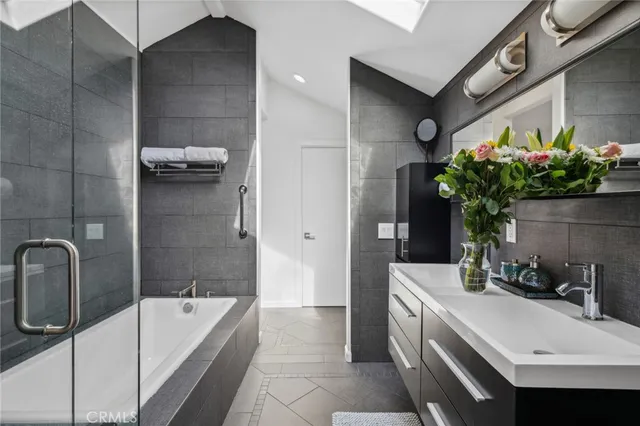 a white bath tub sitting next to a white sink and a mirror