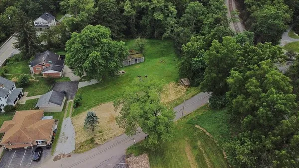 an aerial view of residential houses with outdoor space and trees