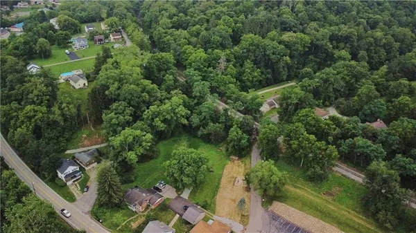 an aerial view of residential houses with outdoor space and trees