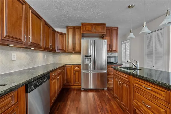 a kitchen with stainless steel appliances granite countertop a refrigerator sink and cabinets