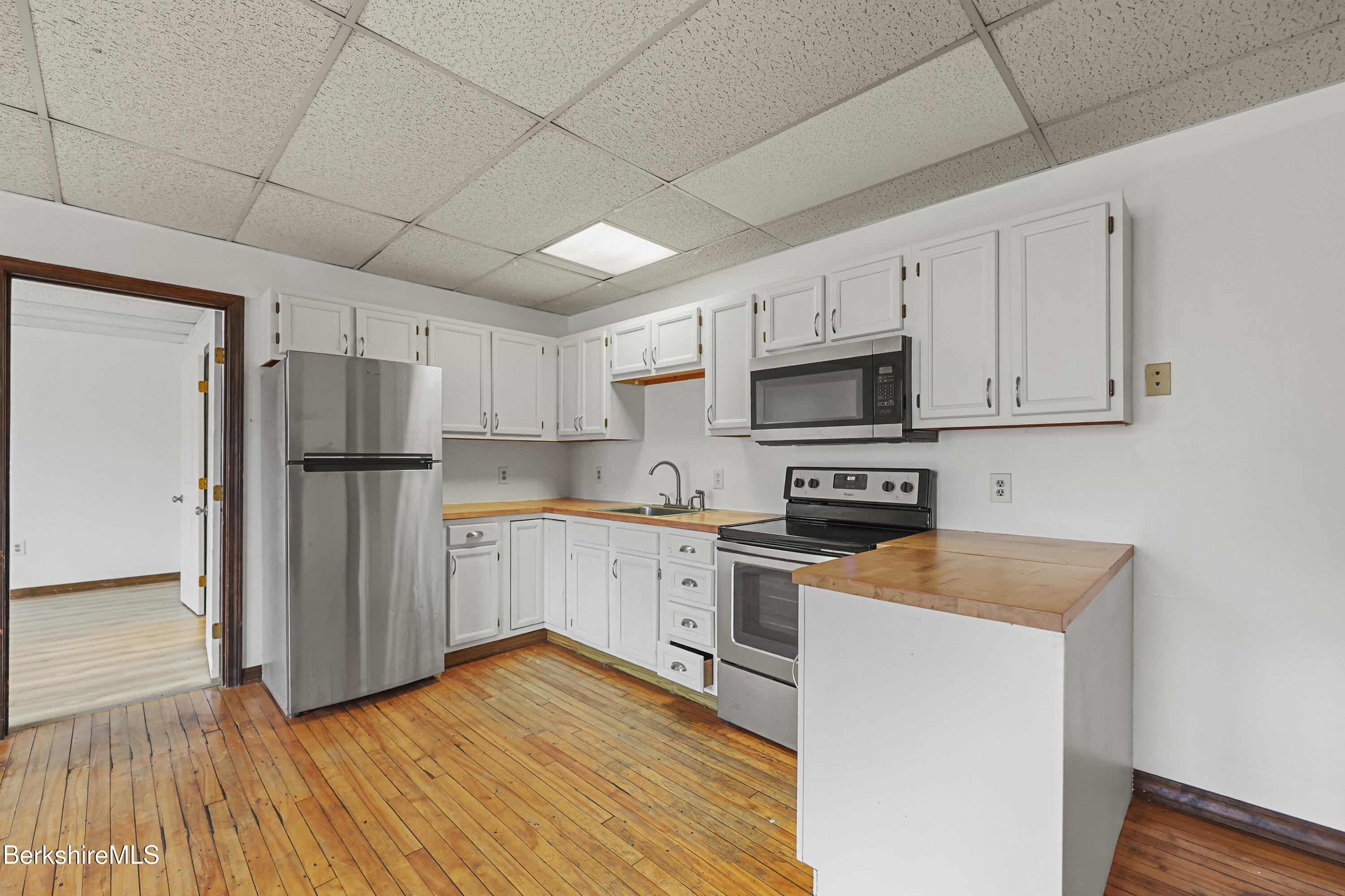 55 Crystal Street, Unit 8 Lenox, MA 01242 - Photo 8 of 12 a kitchen with wooden cabinets and stainless steel appliances