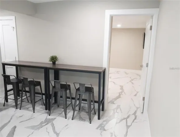 a kitchen with stainless steel appliances a table chairs refrigerator and microwave