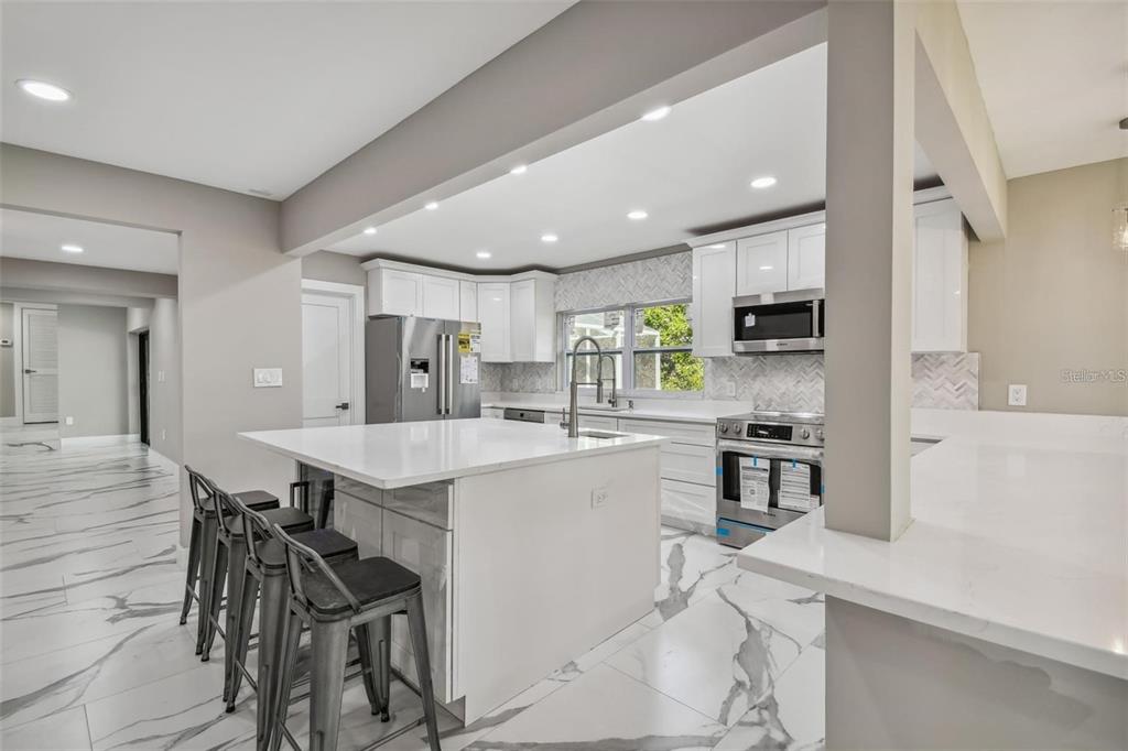2042 Craft Lane Sarasota, FL 34239 - Photo 30 of 100 a kitchen with stainless steel appliances a table chairs refrigerator and microwave