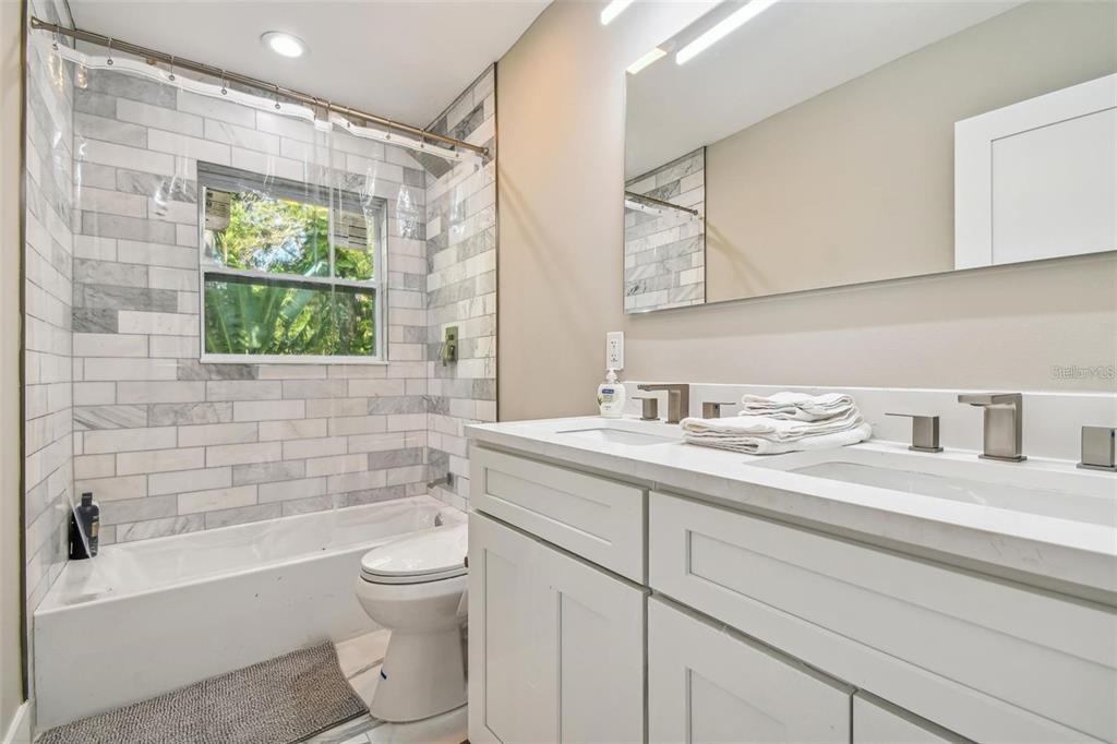 2042 Craft Lane Sarasota, FL 34239 - Photo 66 of 100 a bathroom with a granite countertop toilet a sink and a bathtub