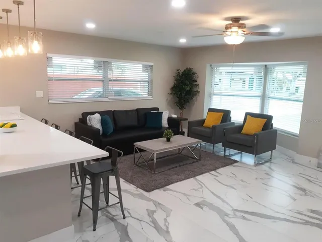 a bedroom with a bed a chair and a chandelier