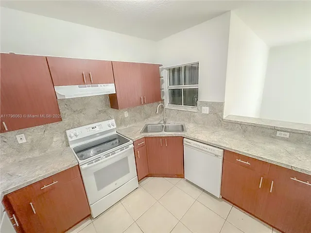 a kitchen with granite countertop a stove top oven microwave and cabinets