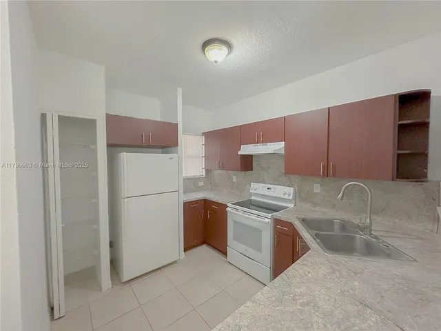 a kitchen with stainless steel appliances granite countertop a refrigerator sink and stove