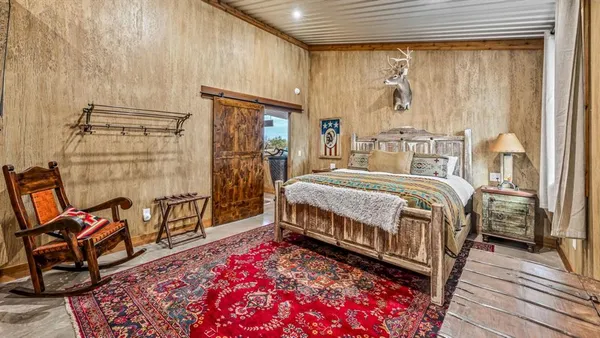 a bedroom with a bed a table and chair