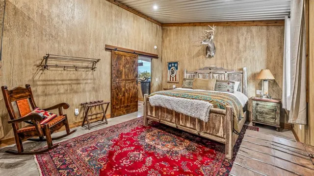 a bedroom with a bed a table and chair