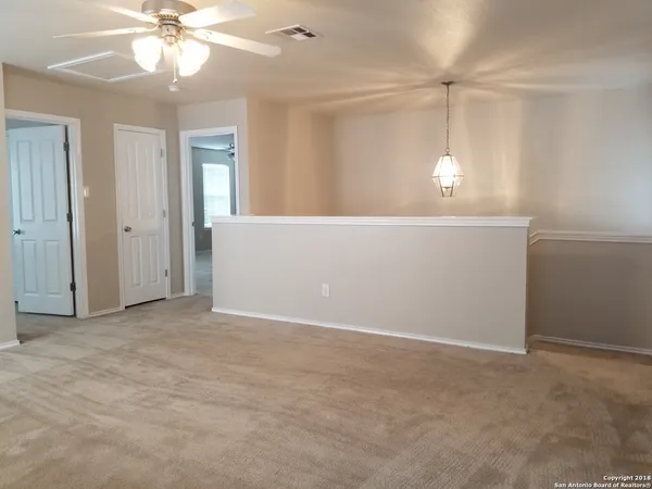 an empty room with windows and fan