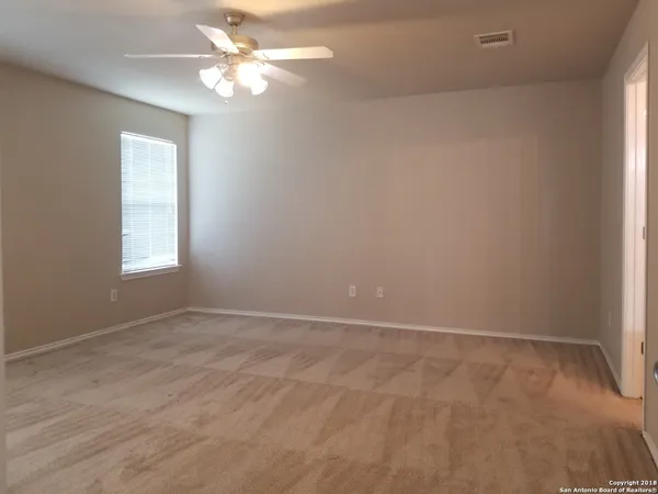 an empty room with windows closet and chandelier fan