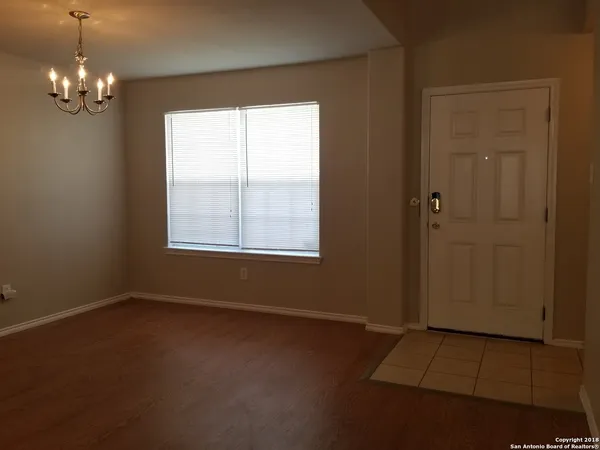 an empty room with windows and chandelier