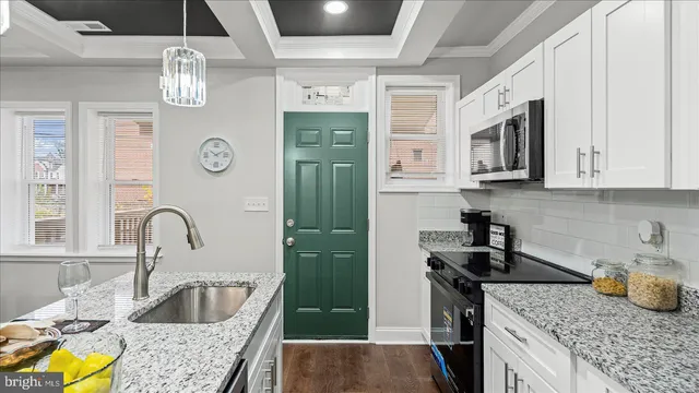 a kitchen with stainless steel appliances granite countertop a sink a stove and a wooden floors