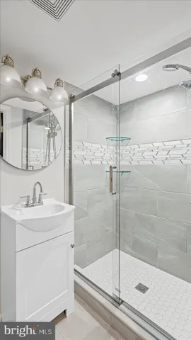 a bathroom with a shower sink and mirror