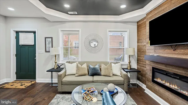 a living room with furniture a flat screen tv and a fireplace