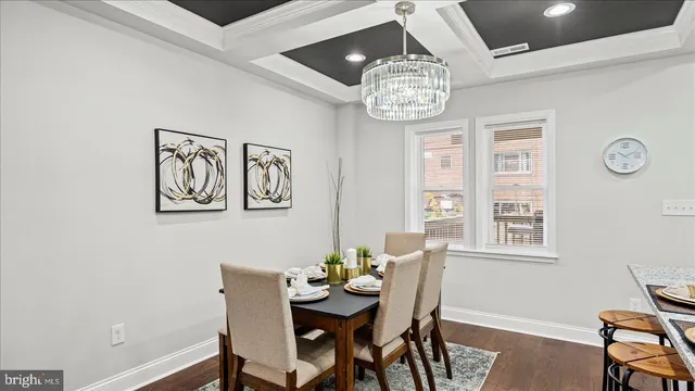 a view of a dining room with furniture a chandelier and wooden floor