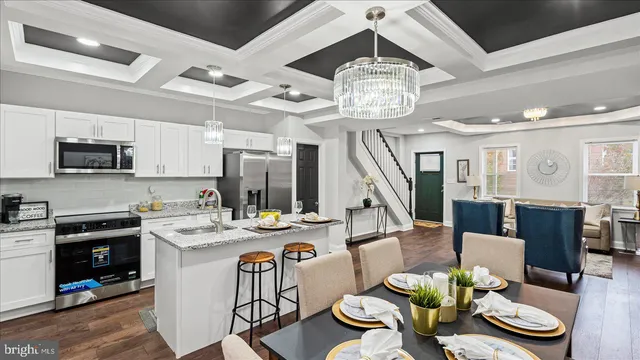 a view of a dining room with furniture a kitchen and chandelier