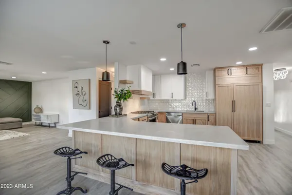 a kitchen with stainless steel appliances a dining table chairs and wooden floor