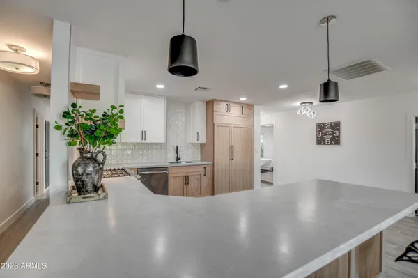 a kitchen with stainless steel appliances granite countertop a sink a refrigerator and a counter top space