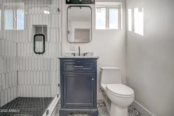 a bathroom with a toilet a sink a vanity and mirror
