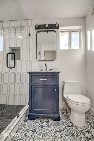 a bathroom with a toilet a sink and mirror