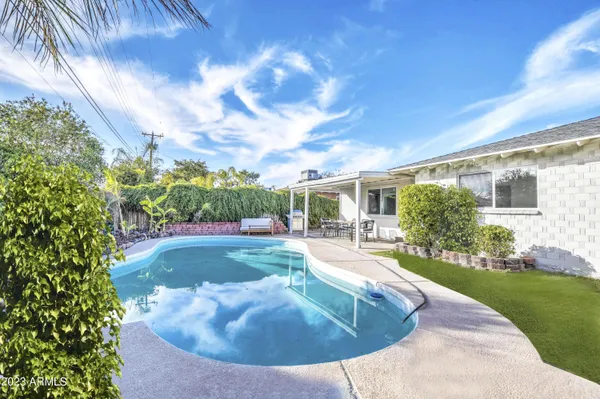 a swimming pool with outdoor seating and yard