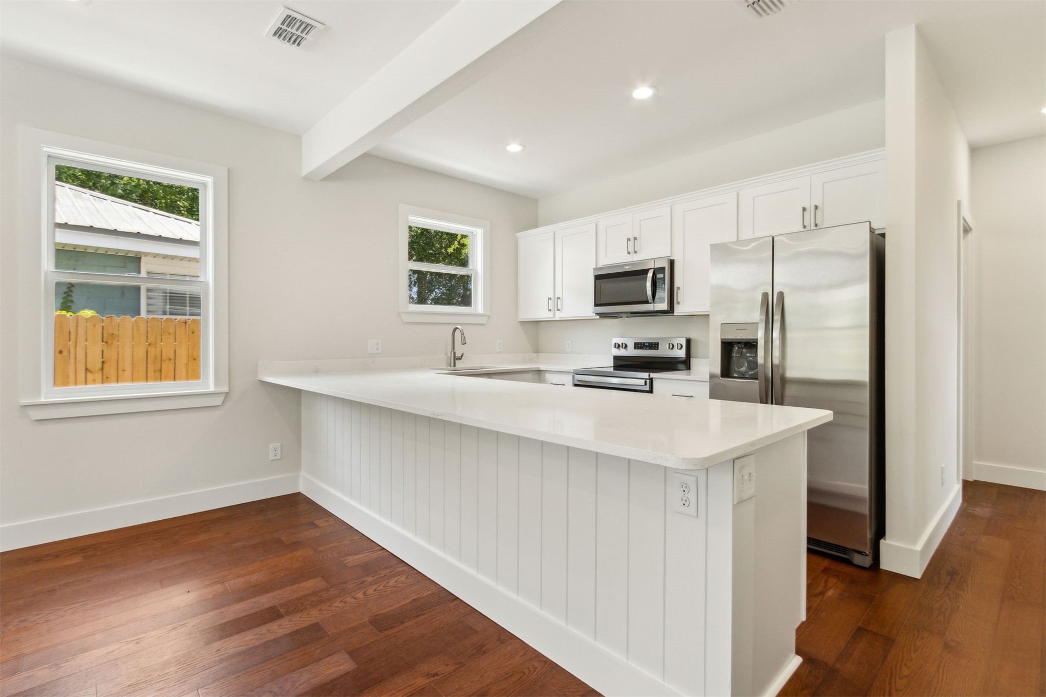929 South 9th Street Fernandina Beach, FL 32034 - Photo 14 of 36 a kitchen with kitchen island a sink wooden floor and a refrigerator